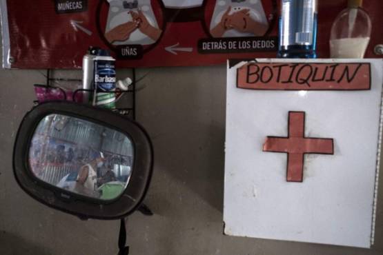 The reflection of an asylum seeker is seen on a mirror in the cleaning area at the Juventud 2000 migrant shelter in Tijuana, Baja California State, Mexico, on April 3, 2020 during the novel coronavirus, COVID-19, pandemic. - Thousands of migrants overcrowding shelters or begging in the streets in Mexican cities along the US border are living in fear as the novel coronavirus spreads in the population and screening interviews for asylum seekers are being suspended. (Photo by Guillermo ARIAS / AFP)