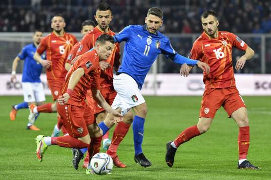 El defensor de Macedonia del Norte, Ezgjan Alioski (L), desafía al delantero de Italia, Domenico Berardi (C), durante el partido de fútbol clasificatorio para la Copa Mundial 2022 entre Italia y Macedonia del Norte.