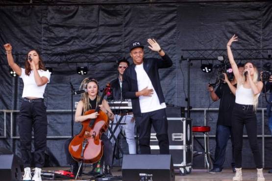EPA233. BONDY (FRANCIA), 17/10/2018.- El futbolista francés Kylian Mbappé (c) saluda junto al grupo musical L.E.J. durante su visita al estadio Leo Lagrange, en Bondy, Francia, el 17 de octubre del 2018. EFE/Christophe Petit Tesson