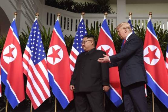US President Donald Trump (R) walks with North Korea's leader Kim Jong Un (L) at the start of their historic US-North Korea summit, at the Capella Hotel on Sentosa island in Singapore on June 12, 2018.Donald Trump and Kim Jong Un became on June 12 the first sitting US and North Korean leaders to meet, shake hands and negotiate to end a decades-old nuclear stand-off. / AFP PHOTO / SAUL LOEB
