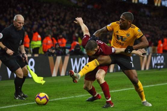 Liverpool's English midfielder James Milner (C) vies with Wolverhampton Wanderers' Portuguese midfielder Ivan Cavaleiro (R) during the English Premier League football match between Wolverhampton Wanderers and Liverpool at the Molineux stadium in Wolverhampton, central England on December 21, 2018. - Liverpool won the game 2-0. (Photo by Geoff CADDICK / AFP) / RESTRICTED TO EDITORIAL USE. No use with unauthorized audio, video, data, fixture lists, club/league logos or 'live' services. Online in-match use limited to 120 images. An additional 40 images may be used in extra time. No video emulation. Social media in-match use limited to 120 images. An additional 40 images may be used in extra time. No use in betting publications, games or single club/league/player publications. /