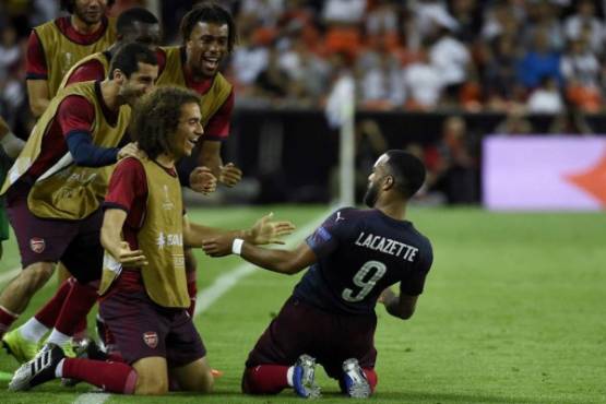 Arsenal's French striker Alexandre Lacazette (R) celebrates with teammates after scoring his team's second goal during the UEFA Europa League semi-final second leg football match between Valencia CF and Arsenal FC at the Mestalla stadium in Valencia on May 9, 2019. (Photo by JOSE JORDAN / AFP)