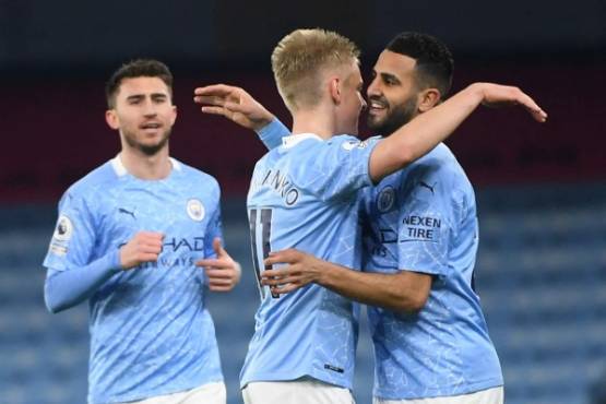Manchester City's Algerian midfielder Riyad Mahrez (R) celebrates with teammates after scoring his team's fourth goal during the English Premier League football match between Manchester City and Southampton at the Etihad Stadium in Manchester, north west England on March 10, 2021. (Photo by Gareth Copley / POOL / AFP) / RESTRICTED TO EDITORIAL USE. No use with unauthorized audio, video, data, fixture lists, club/league logos or 'live' services. Online in-match use limited to 120 images. An additional 40 images may be used in extra time. No video emulation. Social media in-match use limited to 120 images. An additional 40 images may be used in extra time. No use in betting publications, games or single club/league/player publications. /