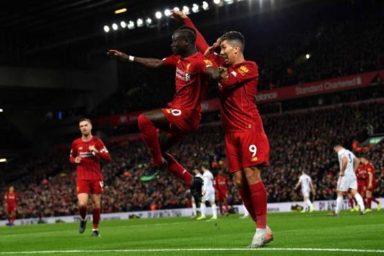 Liverpool's Senegalese striker Sadio Mane (L) celebrates with Liverpool's Brazilian midfielder Roberto Firmino after he scores his team's second goal during the English Premier League football match between Liverpool and Sheffield United at Anfield in Liverpool, north west England on January 2, 2020. (Photo by Paul ELLIS / AFP) / RESTRICTED TO EDITORIAL USE. No use with unauthorized audio, video, data, fixture lists, club/league logos or 'live' services. Online in-match use limited to 120 images. An additional 40 images may be used in extra time. No video emulation. Social media in-match use limited to 120 images. An additional 40 images may be used in extra time. No use in betting publications, games or single club/league/player publications. /