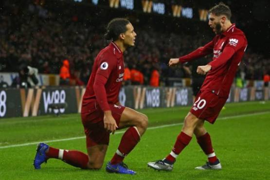 Liverpool's Dutch defender Virgil van Dijk celebrates with Liverpool's English midfielder Adam Lallana (R) after scoring their second goal during the English Premier League football match between Wolverhampton Wanderers and Liverpool at the Molineux stadium in Wolverhampton, central England on December 21, 2018. (Photo by Geoff CADDICK / AFP) / RESTRICTED TO EDITORIAL USE. No use with unauthorized audio, video, data, fixture lists, club/league logos or 'live' services. Online in-match use limited to 120 images. An additional 40 images may be used in extra time. No video emulation. Social media in-match use limited to 120 images. An additional 40 images may be used in extra time. No use in betting publications, games or single club/league/player publications. /