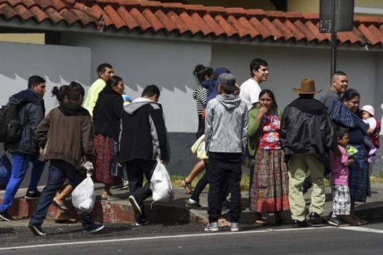 Migrants deported from the United States are seen outside the air force base upon their arrival in Guatemala City on December 12, 2019. - 119 migrants of Guatemala, El Salvador and Honduras deported from the US arrived in the Central American country on Thursday, following the signing of an asylum agreement between the two countries, amid a migrant crisis in the region. (Photo by Orlando ESTRADA / AFP)