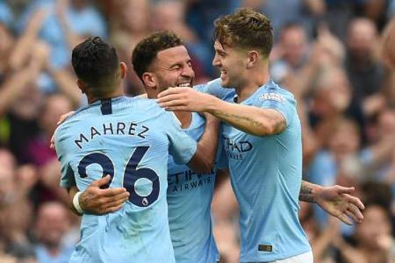 Manchester City's English defender Kyle Walker (C) celebrates with Manchester City's Algerian midfielder Riyad Mahrez (L0 and Manchester City's English defender John Stones (R) after scoring their second goal during the English Premier League football match between Manchester City and Newcastle United at the Etihad Stadium in Manchester, north west England, on September 1, 2018. / AFP PHOTO / Oli SCARFF / RESTRICTED TO EDITORIAL USE. No use with unauthorized audio, video, data, fixture lists, club/league logos or 'live' services. Online in-match use limited to 120 images. An additional 40 images may be used in extra time. No video emulation. Social media in-match use limited to 120 images. An additional 40 images may be used in extra time. No use in betting publications, games or single club/league/player publications. /