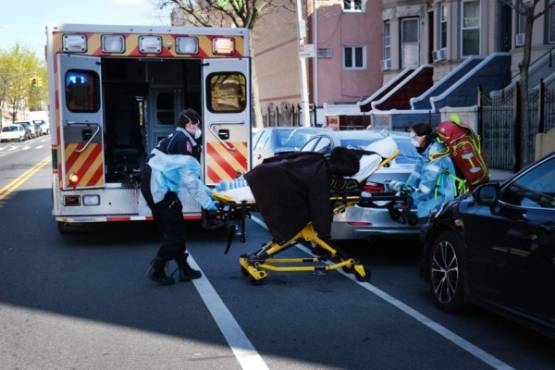 NEW YORK, NY - APRIL 11: Health workers carry a patient to an ambulance on April 11, 2020 in the Brooklyn borough of New York City. According to John Hopkins University, the global death toll from COVID-19 has now reached 100,000 worldwide with many experts believing that the number is actually higher. Spencer Platt/Getty Images/AFP