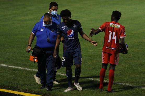 El dolor era tan intenso que el defensor del Motagua no podía apoyar bien su pie derecho. Le ayudó apoyarse el experimentado fisioterapeuta de Motagua, Gerardo Mejía. Foto: Marvin Salgado.