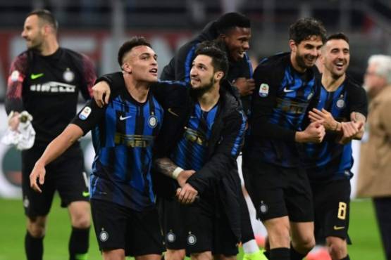 Inter Milan's Argentine forward Lautaro Martinez (L), Inter Milan's Italian midfielder Matteo Politano (C) and teammates celebrate winning the Italian Serie A football match AC Milan vs Inter Milan at the San Siro stadium in Milan. (Photo by Miguel MEDINA / AFP)