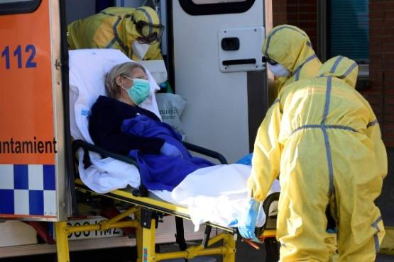 Civil Defence members carry a patient on a stretcher as they arrive at the Severo Ochoa hospital in Leganes, on March 26, 2020. - Spain's coronavirus death toll surged above 4,000 today but the increase in both fatalities and new infections slowed, leaving officials hopeful a nationwide lockdown is starting to curb the spread of the disease. A total of 655 deaths were recorded in the country in the last 24 hours, bringing the toll to 4,089, the health ministry said. (Photo by JAVIER SORIANO / AFP)