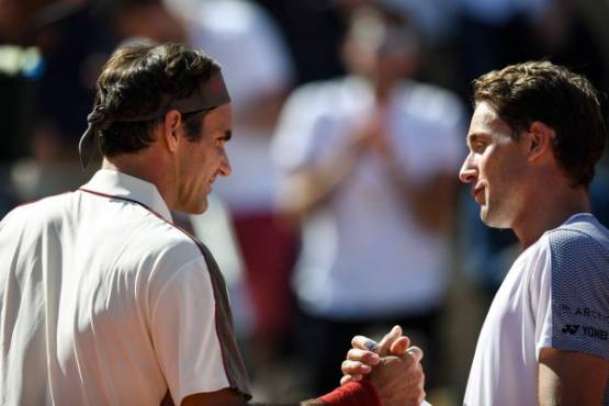 Switzerland's Roger Federer (L) and Norway's Casper Ruud shake hands at the end of their men's singles third round match on day six of The Roland Garros 2019 French Open tennis tournament in Paris on May 31, 2019. (Photo by Christophe ARCHAMBAULT / AFP)