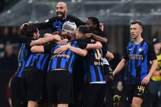 Inter Milan's Spanish midfielder Borja Valero (Top L), Inter Milan's Croatian midfielder Ivan Perisic (R) and teammates celebrate winning the Italian Serie A football match AC Milan vs Inter Milan at the San Siro stadium in Milan. (Photo by Miguel MEDINA / AFP)