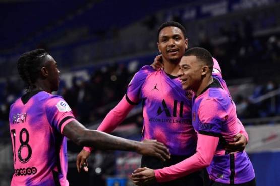 Paris Saint-Germain's French forward Kylian Mbappe (R) celebrates with teammates after scoring a goal during the French L1 football match between Lyon (OL) and Paris Saint-Germain (PSG) at the Groupama Stadium in Decines-Charpieu, near Lyon, central-eastern France, on March 21, 2021. (Photo by JEFF PACHOUD / AFP)
