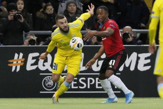 Astana's Kazakh forward Sergei Khizhnichenko and Manchester United's defender Ethan Laird vie for the ball during the UEFA Europa League group L football match between Astana and Manchester United in Nur-Sultan on November 28, 2019. (Photo by stringer / AFP)