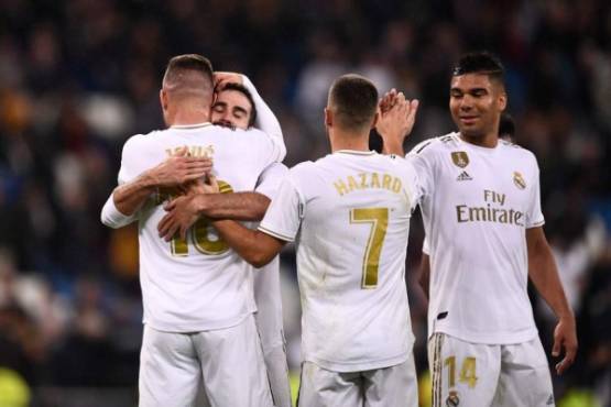 Real Madrid's Serbian forward Luka Jovic (L) is congratulated by teammates after scoring the fifth and last goal during the Spanish league football match between Real Madrid CF and Club Deportivo Leganes SAD at the Santiago Bernabeu stadium in Madrid on October 30, 2019. (Photo by OSCAR DEL POZO / AFP)