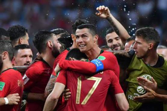 Portugal's forward Cristiano Ronaldo (C) celebrates his second goal with teammates during the Russia 2018 World Cup Group B football match between Portugal and Spain at the Fisht Stadium in Sochi on June 15, 2018. / AFP PHOTO / Nelson Almeida / RESTRICTED TO EDITORIAL USE - NO MOBILE PUSH ALERTS/DOWNLOADS