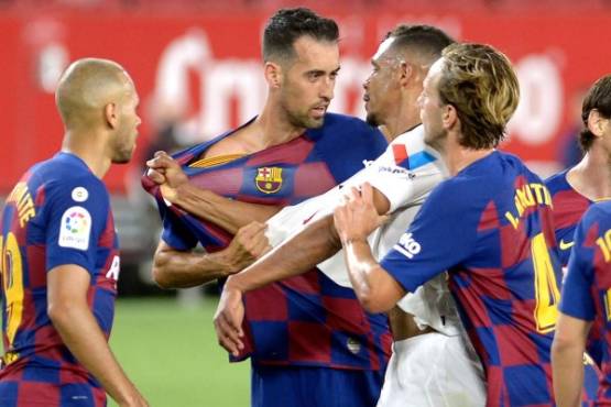Barcelona's Spanish midfielder Sergio Busquets (2ndL) argues with Sevilla's Brazilian midfielder Fernando (2ndR) during the Spanish league football match between Sevilla FC and FC Barcelona at the Ramon Sanchez Pizjuan stadium in Seville on June 19, 2020. (Photo by CRISTINA QUICLER / AFP)