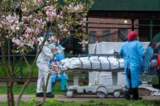 NEW YORK, NY - APRIL 8: Kingsbrook Jewish Medical Center employees transport a deceased patient to a refrigerated truck on April 8, 2020 in the Brooklyn borough of New York City. One of the city's hardest impacted hospitals due to the coronavirus (COVID-19), Kingsbrook has begun storing the bodies of the the deceased in refrigerated trucks. David Dee Delgado/Getty Images/AFP
