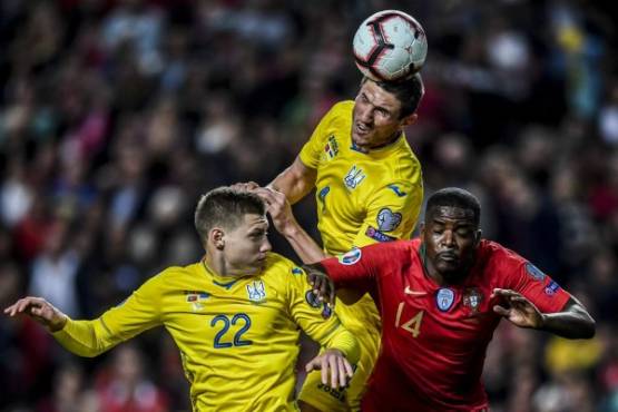 Portugal's midfielder William Carvalho (R) heads the ball next to Ukraine's defender Sergii Kryvtsov (C) and Ukraine's defender Mykola Matviyenko (L) during the Euro 2020 qualifying football match Portugal vs Ukraine at Luz stadium in Lisbon on March 22, 2019. (Photo by PATRICIA DE MELO MOREIRA / AFP)