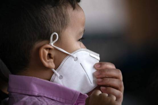 BROWNSVILLE, TEXAS - FEBRUARY 26: A child sits with his family in an isolation area after he tested positive for Covid-19, according to his mother who also tested positive, after their arrival to the U.S. on February 26, 2021 in Brownsville, Texas. U.S. immigration authorities are now releasing many asylum seeking families after they cross the U.S.-Mexico border and are taken into custody. The immigrant families are then free to travel to destinations throughout the U.S. while awaiting asylum hearings. John Moore/Getty Images/AFP (Photo by JOHN MOORE / GETTY IMAGES NORTH AMERICA / Getty Images via AFP)