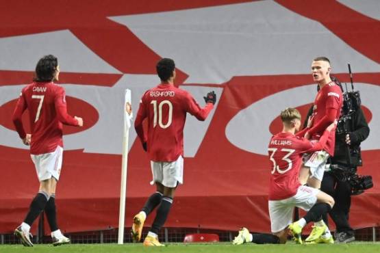 Manchester United's Scottish midfielder Scott McTominay (R) celebrates with teammates after scoring his team's first goal during the English FA Cup fifth round football match between Manchester United and West Ham United at Old Trafford in Manchester, north west England, on February 9, 2021. (Photo by Michael Regan / POOL / AFP) / RESTRICTED TO EDITORIAL USE. No use with unauthorized audio, video, data, fixture lists, club/league logos or 'live' services. Online in-match use limited to 120 images. An additional 40 images may be used in extra time. No video emulation. Social media in-match use limited to 120 images. An additional 40 images may be used in extra time. No use in betting publications, games or single club/league/player publications. /