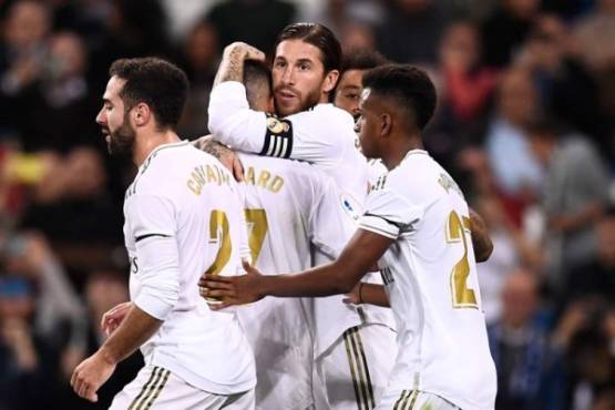 Real Madrid's Spanish defender Sergio Ramos (C) is congratulated by teammates after scoring a penalty goal during the Spanish league football match between Real Madrid CF and Club Deportivo Leganes SAD at the Santiago Bernabeu stadium in Madrid on October 30, 2019. (Photo by OSCAR DEL POZO / AFP)