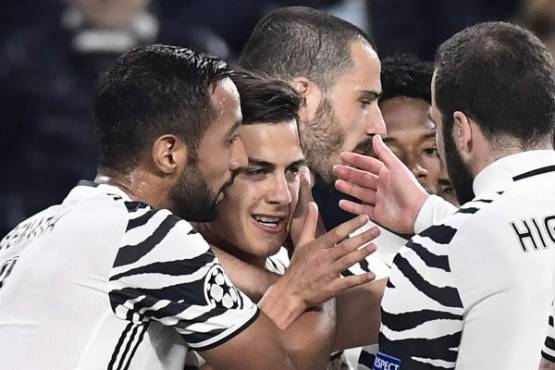 Juventus' forward from Argentina Paulo Dybala (2ndL) is congratulated by teammates after scoring a penalty during the UEFA Champions League football match Juventus vs FC Porto on March 14, 2017 at the Juventus stadium in Turin. / AFP PHOTO / MIGUEL MEDINA