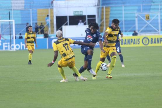 El Búho Meléndez intenta pasar entre dos defensores de Real España.