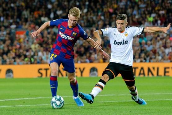 Barcelona's Dutch midfielder Frenkie De Jong (L) vies with Valencia's Brazilian defender Gabriel Paulista during the Spanish league football match FC Barcelona against Valencia CF at the Camp Nou stadium in Barcelona on September 14, 2019. (Photo by Pau Barrena / AFP)
