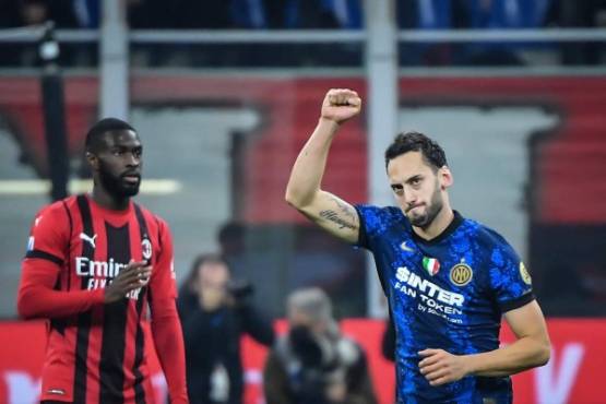 Inter Milan's Turkish midfielder Hakan Calhanoglu (R) celebrates after scoring a goal during the Italian Serie A football match between AC Milan and Inter on November 7, 2021 at the San Siro stadium, in Milan. (Photo by Tiziana FABI / AFP)