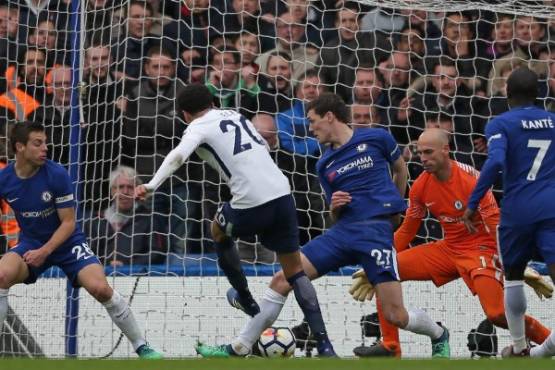 Tottenham Hotspur's English midfielder Dele Alli (C) shoots to score their third goal during the English Premier League football match between Chelsea and Tottenham Hotspur at Stamford Bridge in London on April 1, 2018. / AFP PHOTO / Daniel LEAL-OLIVAS / RESTRICTED TO EDITORIAL USE. No use with unauthorized audio, video, data, fixture lists, club/league logos or 'live' services. Online in-match use limited to 75 images, no video emulation. No use in betting, games or single club/league/player publications. /