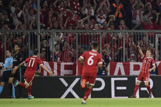 Bayern Munich's German midfielder Joshua Kimmich (R) celebrates after scoring during the UEFA Champions League semi-final first-leg football match FC Bayern Munich v Real Madrid CF in Munich, southern Germany on April 25, 2018. / AFP PHOTO / JAVIER SORIANO