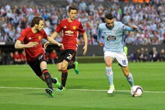 Celta Vigo's forward Iago Aspas (R) vies with Manchester United's Dutch midfielder Daley Blind (L) and Manchester United's Spanish midfielder Ander Herrera during their UEFA Europa League semi final first leg football match RC Celta de Vigo vs Manchester United FC at the Balaidos stadium in Vigo on May 4, 2017. / AFP PHOTO / CESAR MANSO