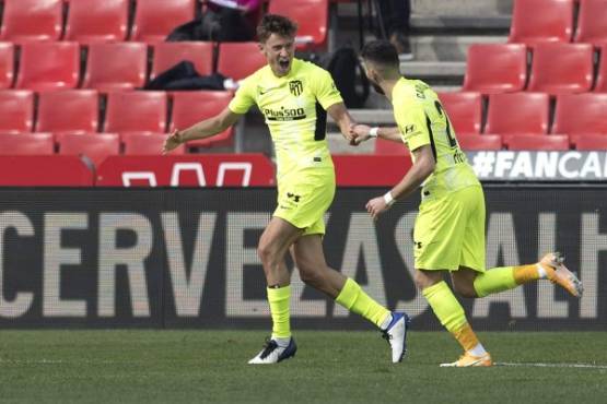 Atletico Madrid's Spanish midfielder Marcos Llorente (L) celebrates after scoring a goal during the Spanish league football match between Granada FC and Club Atletico de Madrid at Nuevo Los Carmenes stadium in Granada on February 13, 2021. (Photo by JORGE GUERRERO / AFP)