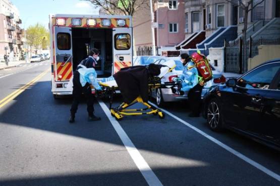 NEW YORK, NY - APRIL 11: Health workers carry a patient to an ambulance on April 11, 2020 in the Brooklyn borough of New York City. According to John Hopkins University, the global death toll from COVID-19 has now reached 100,000 worldwide with many experts believing that the number is actually higher. Spencer Platt/Getty Images/AFP