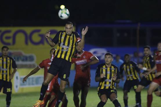 Devron García intenta despejar el balón para evitar el peligro en la portería de Michael Perelló.