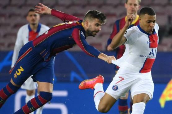 Barcelona's Spanish defender Gerard Pique (L) challenges Paris Saint-Germain's French forward Kylian Mbappe during the UEFA Champions League round of 16 first leg football match between FC Barcelona and Paris Saint-Germain FC at the Camp Nou stadium in Barcelona on February 16, 2021. (Photo by LLUIS GENE / AFP)