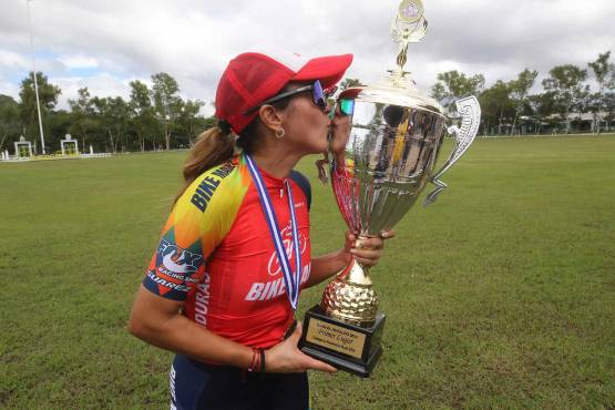 Giselle Andino besando el trofeo que se llevó en la Vuelta Ciclísitica 2023. FOTO: Estalin Irias.