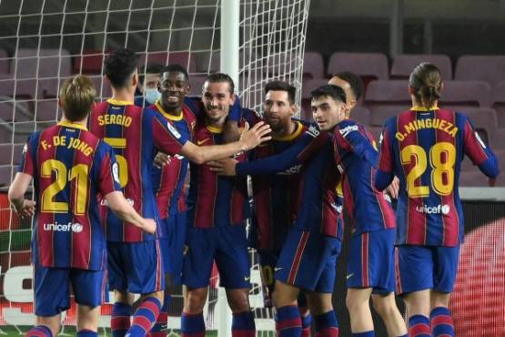 Barcelona's French midfielder Antoine Griezmann (C) celebrates with teammates after scoring a goal during the Spanish League football match between Barcelona and SD Huesca at the Camp Nou stadium in Barcelona on March 15, 2021. (Photo by LLUIS GENE / AFP)