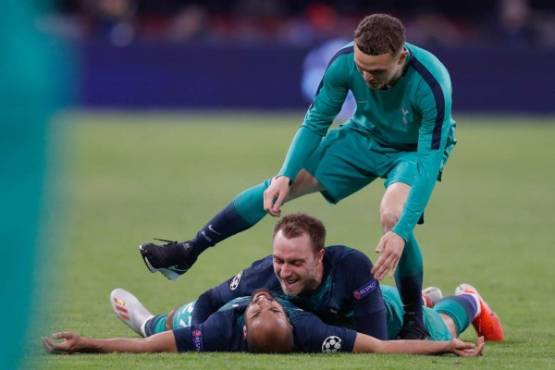 Tottenham's Brazilian forward Lucas celebrates after scoring a goal with teammate Tottenham's Danish midfielder Christian Eriksen (C) and Tottenham's English defender Kieran Trippier (up) during the UEFA Champions League semi-final second leg football match between Ajax Amsterdam and Tottenham Hotspur at the Johan Cruyff Arena, in Amsterdam, on May 8, 2019. (Photo by Adrian DENNIS / AFP)