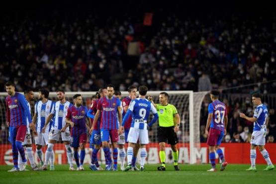 Spanish referee Carlos del Cerro Grande (C) speaks with players during the Spanish league football match between FC Barcelona and RCD Espanyol, at the Camp Nou stadium in Barcelona on November 20, 2021. (Photo by Pau BARRENA / AFP)