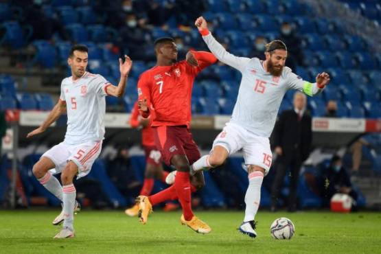 Spain's midfielder Sergio Busquets (L) and Spain's defender Sergio Ramos (R) fight for the ball with Switzerland's forward Breel Embolo (C) during the UEFA Nations League football match between Switzerland and Spain at St. Jakob-Park stadium in Basel, on November 14, 2020. (Photo by Fabrice COFFRINI / AFP)