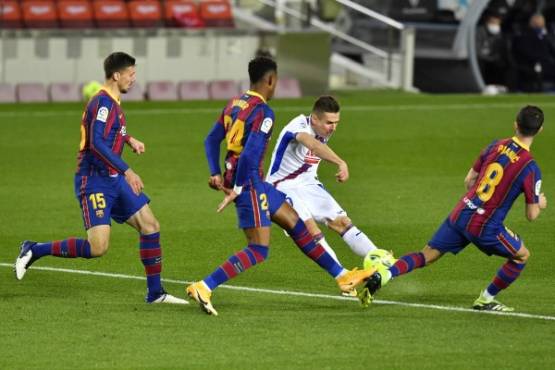 Eibar's Spanish forward Sergi Enrich (C) challenges Barcelona's French defender Clement Lenglet (L), Barcelona's Spanish defender Junior Firpo (2ndL) and Barcelona's Bosnian midfielder Miralem Pjanic (R) during the Spanish League football match between Barcelona and Eibar at the Camp Nou stadium in Barcelona on December 29, 2020. (Photo by Pau BARRENA / AFP)
