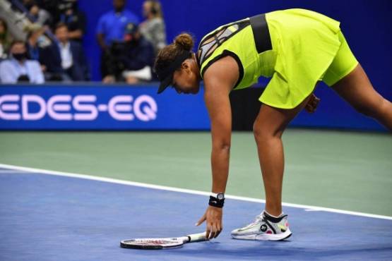 Japan's Naomi Osaka picks up her racket during her 2021 US Open Tennis tournament women's singles third round match against Canada's Leylah Fernandez at the USTA Billie Jean King National Tennis Center in New York, on September 3, 2021. (Photo by Ed JONES / AFP)