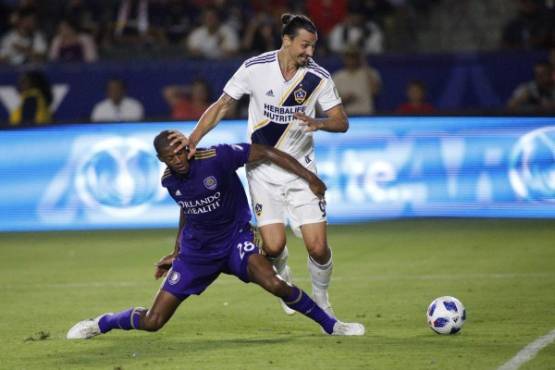 CARSON, CA - JULY 29: Zlatan Ibrahimovic #9 of the Los Angeles Galaxy and Chris Schuler #28 of the Orlando City FC fight for control of the ball at StubHub Center on July 29, 2018 in Carson, California. Katharine Lotze/Getty Images/AFP== FOR NEWSPAPERS, INTERNET, TELCOS & TELEVISION USE ONLY ==