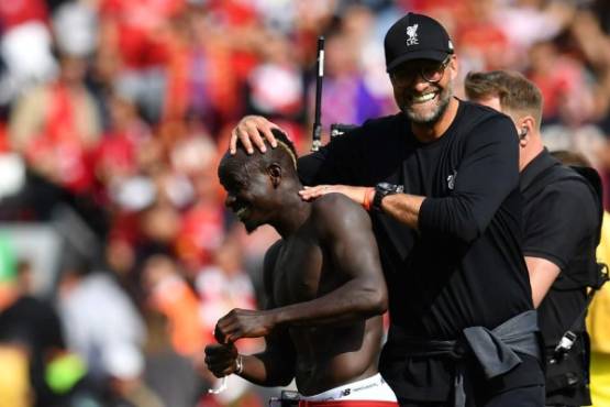 Liverpool's German manager Jurgen Klopp (R) gestures with Liverpool's Senegalese striker Sadio Mane at the final whistle during the English Premier League football match between Liverpool and Newcastle at Anfield in Liverpool, north west England on September 14, 2019. (Photo by Paul ELLIS / AFP) / RESTRICTED TO EDITORIAL USE. No use with unauthorized audio, video, data, fixture lists, club/league logos or 'live' services. Online in-match use limited to 120 images. An additional 40 images may be used in extra time. No video emulation. Social media in-match use limited to 120 images. An additional 40 images may be used in extra time. No use in betting publications, games or single club/league/player publications. /