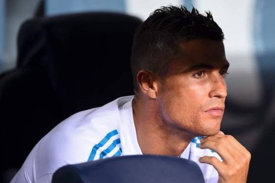 Real Madrid's Portuguese forward Cristiano Ronaldo looks from the bench during the first leg of the Spanish Supercup football match between FC Barcelona and Real Madrid CF at the Camp Nou stadium in Barcelona on August 13, 2017. / AFP PHOTO / Josep LAGO