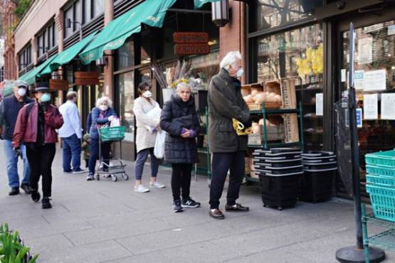 NEW YORK, NEW YORK - APRIL 07: People line up to get into a grocery store during the coronavirus pandemic on April 07, 2020 in New York City. COVID-19 has spread to most countries around the world, claiming almost 70,000 lives with infections nearing 1.3 million people. Cindy Ord/Getty Images/AFP