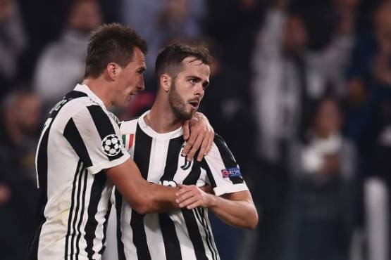 Juventus' forward from Croatia Mario Mandzukic (L) celebrates with Juventus midfielder Miralem Pjanic after scoring during the UEFA Champions League Group D football match Juventus vs Sporting CP at the Juventus stadium on October 17, 2017 in Turin. Juventus won 2-1. / AFP PHOTO / Marco BERTORELLO